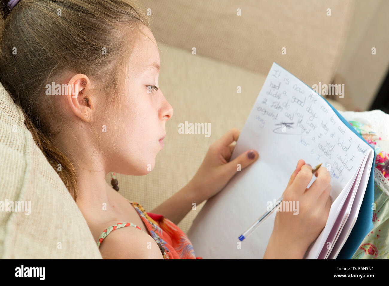 young girl writing essay / doing homework / in diary Stock Photo