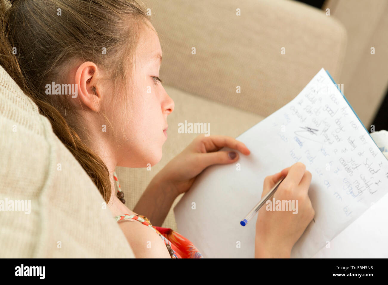 young girl writing essay / doing homework / in diary Stock Photo