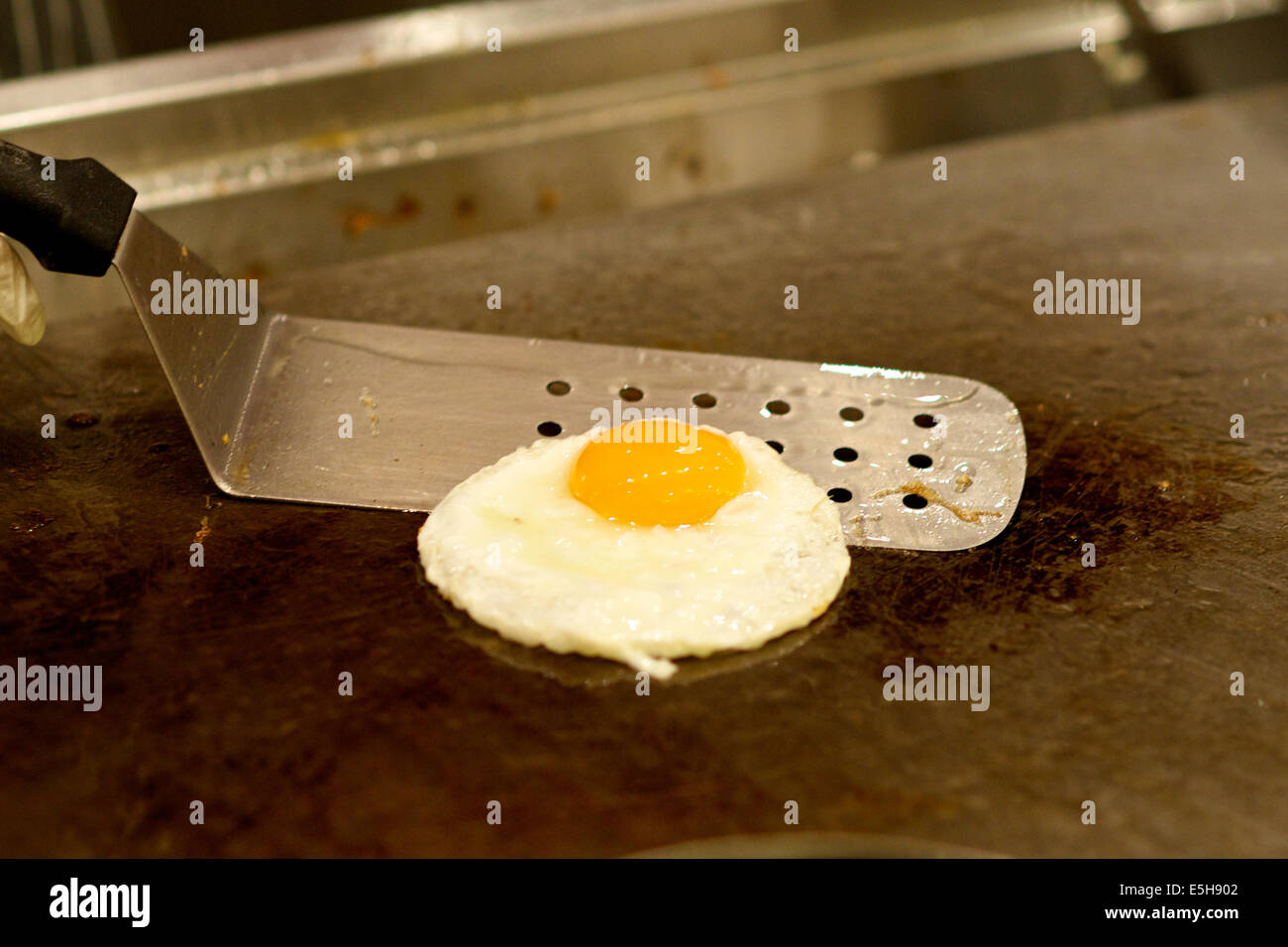 Frying a sunny side up egg in a hotel restaurant Stock Photo