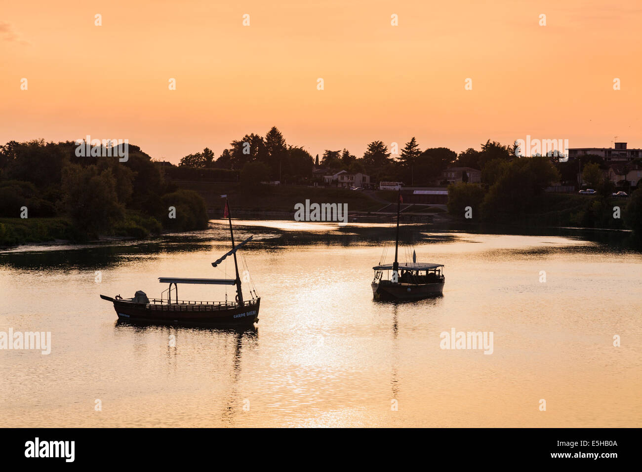 Tourists boats moored on the Dordogne at Bergerac at dusk. Stock Photo