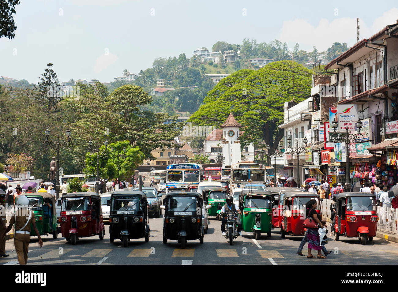 people-walk-across-the-main-road-tuk-tuks-waiting-in-a-row-kandy-sri-E5HBCJ.jpg