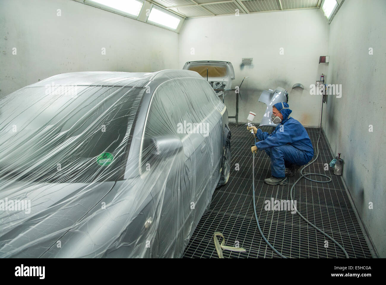 Painting an accidental damage of a car in a garage. Stock Photo