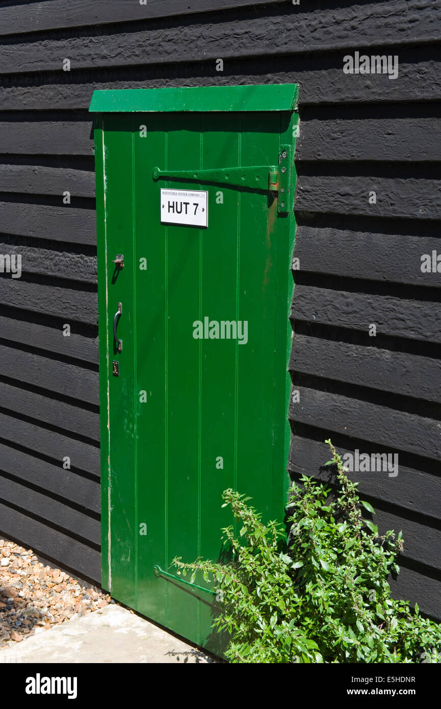 Wooden green front door of renovated fishermens hut now holiday homes