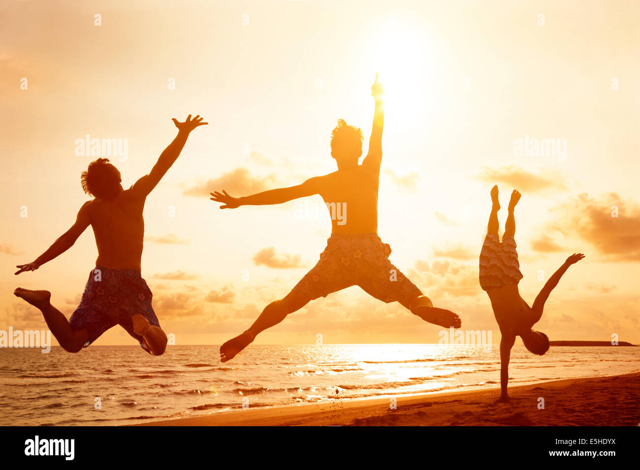 young people jumping on the beach with sunset background Stock Photo ...