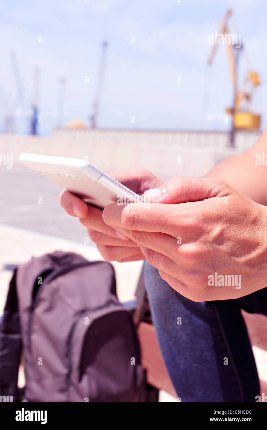 a young man using a tablet or an e-book outdoors Stock Photo