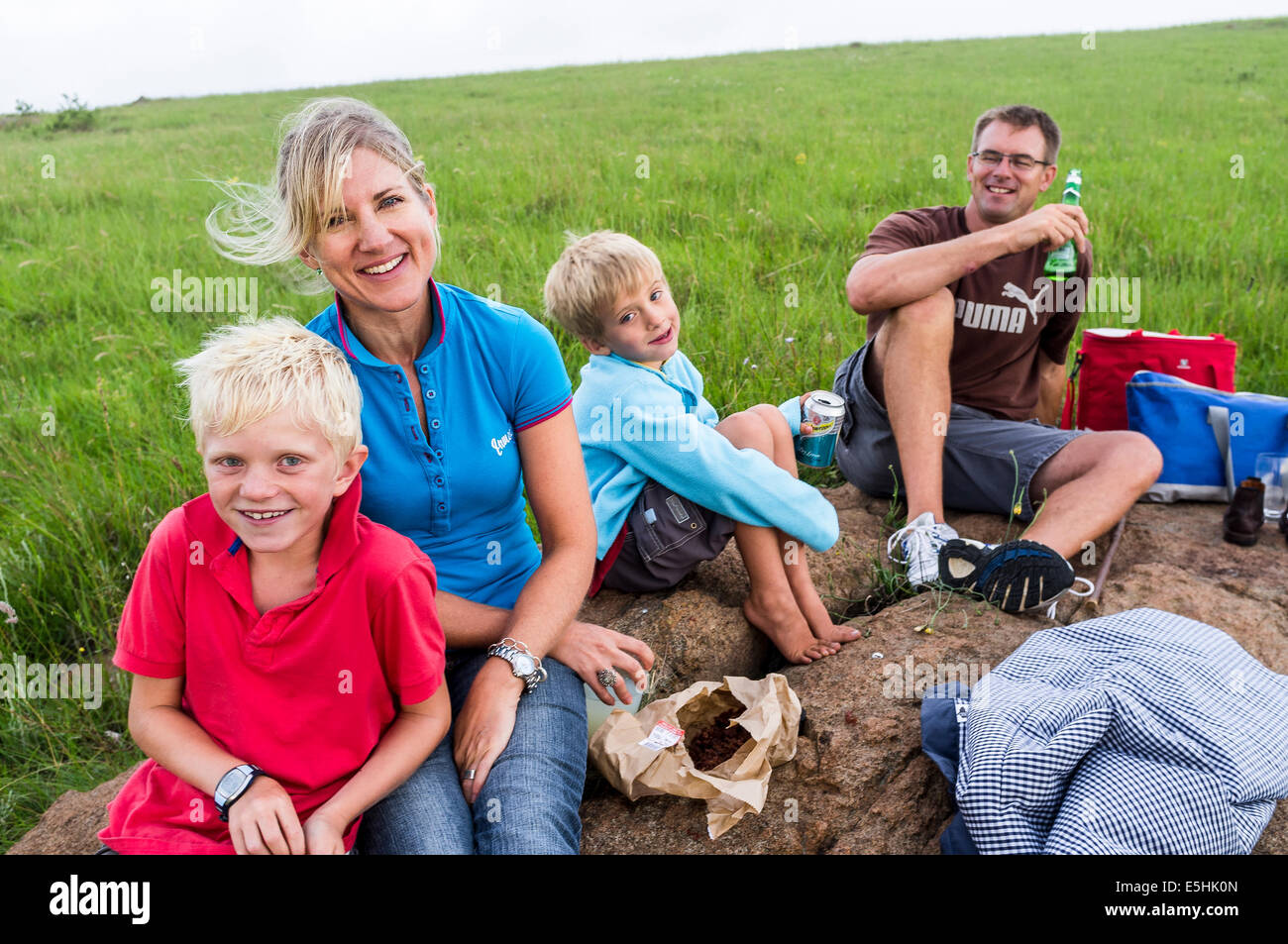 Family of four resting for picnic on rock Stock Photo