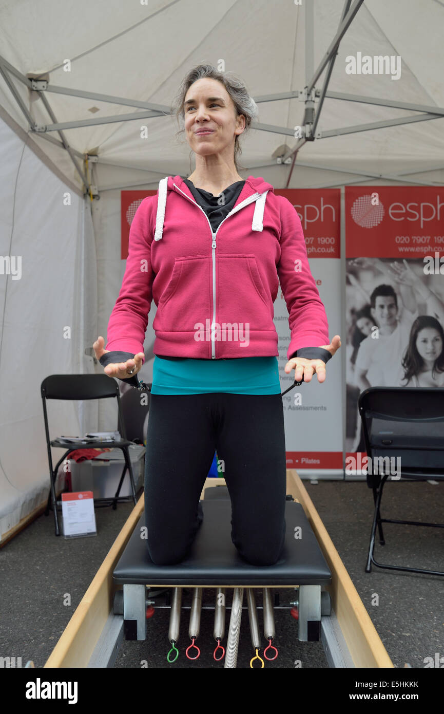 Attractive a woman demonstrating fitness strength training at Marylebone Street Summer Fayre fair festival party, London, UK. Stock Photo