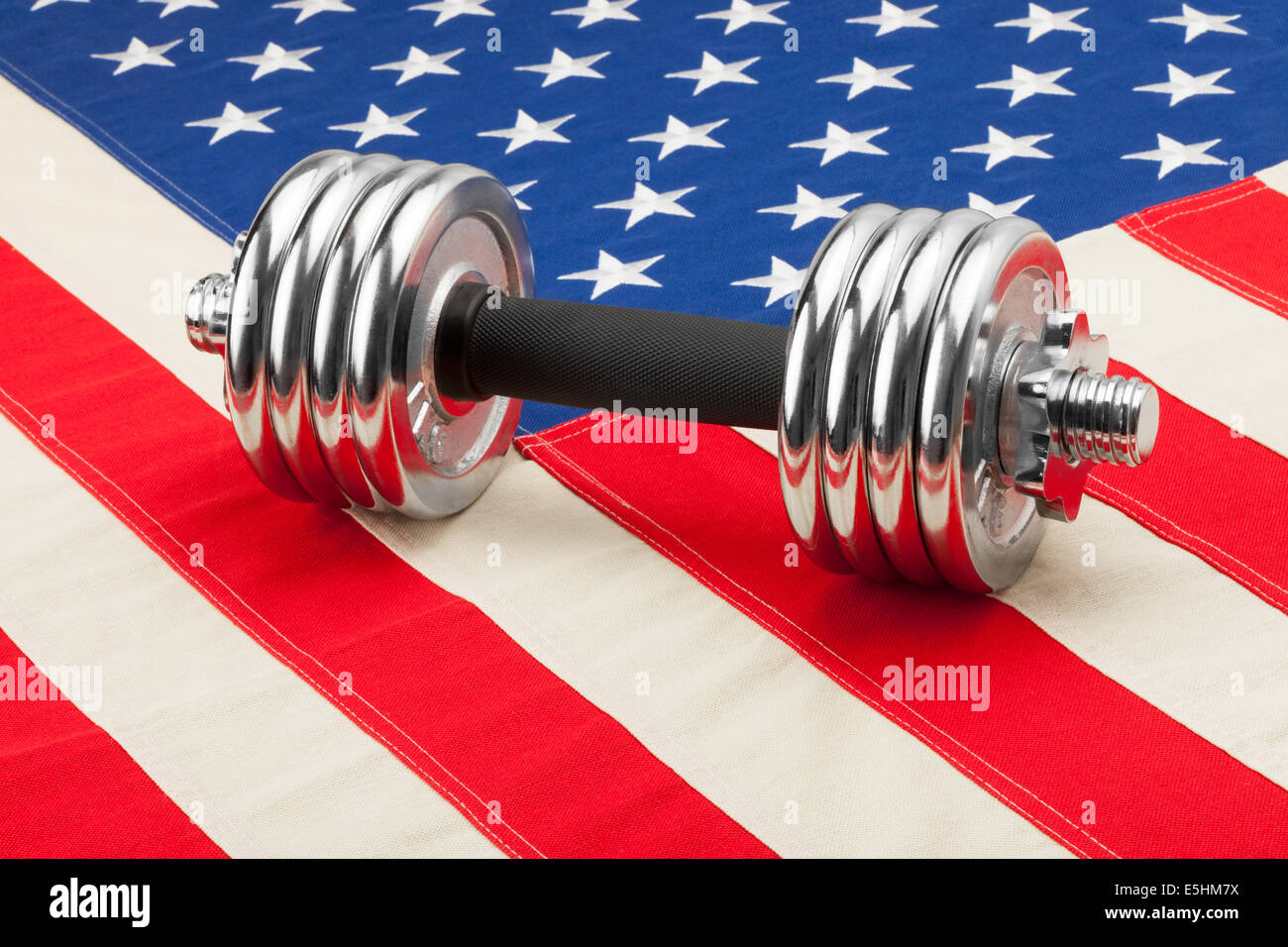 Dumbbell weights over USA flag as symbol of healthy nation Stock Photo