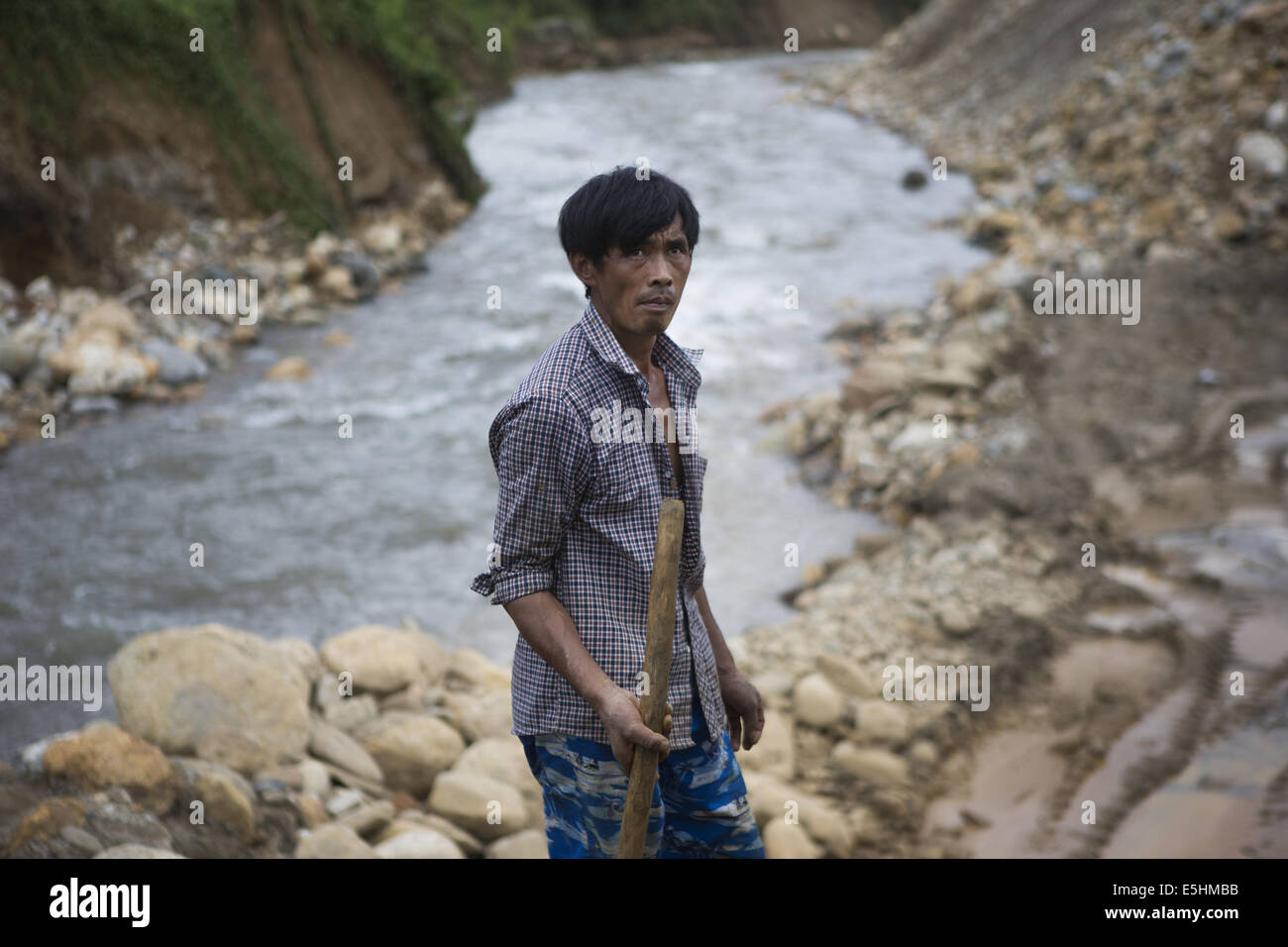 Laiza, Kachin, Myanmar. 9th July, 2014. A Chinese miner at a gold mining site near Laiza, Kachin State, Myanmar. In mineral-rich areas of Kachin State, taxes from Burmese and Chinese gold mining provides an important income stream to the Kachin Independence Organization. However, these mining companies use mercury in an environmentally hazardous extraction process, which can lead to long-lasting damage for the area's forests and river ways. © Taylor Weidman/ZUMA Wire/Alamy Live News Stock Photo