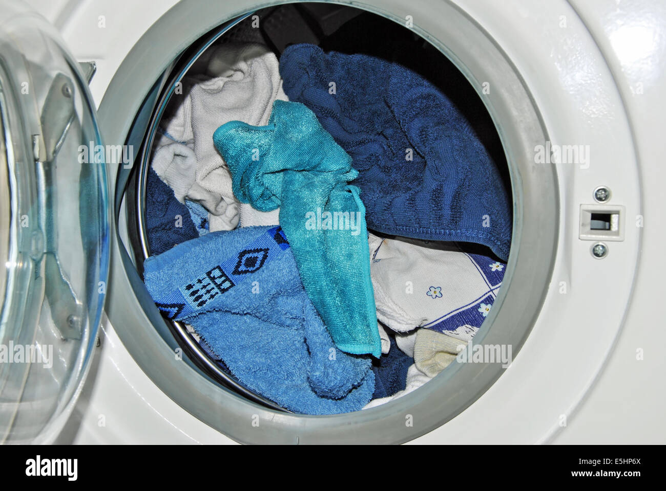 https://c8.alamy.com/comp/E5HP6X/close-up-of-an-open-door-of-a-loaded-washing-machine-with-laundry-E5HP6X.jpg