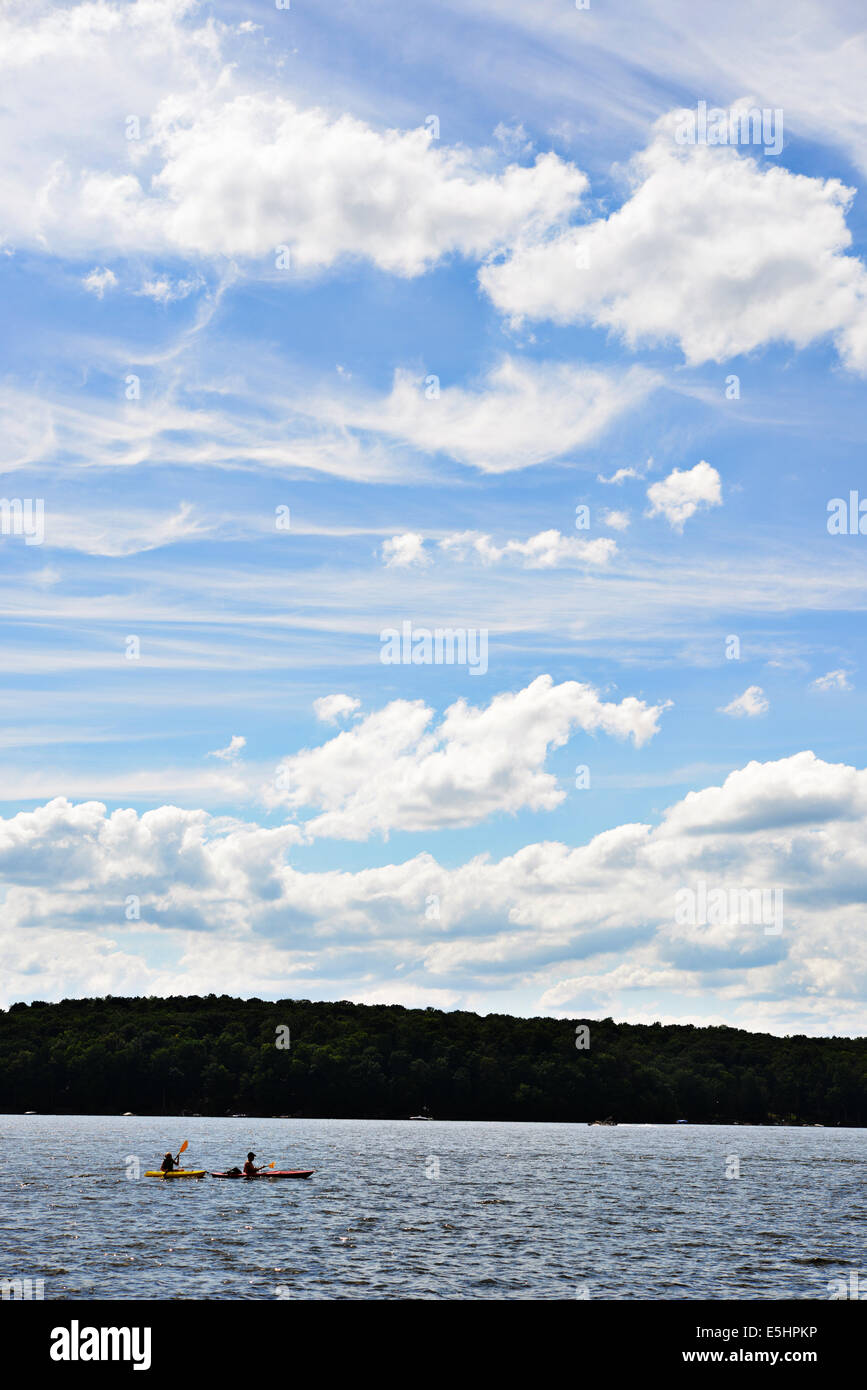 Lake with beautiful clouds in a blue sky with two kayaks Stock Photo