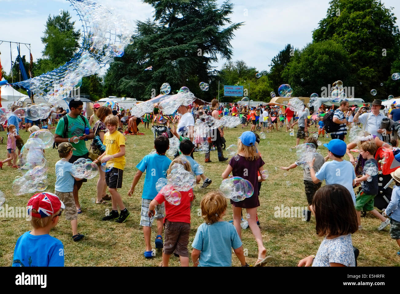 Malmesbury, UK, 26/07/2014 : Atmosphere at WOMAD - World of Music, Arts and Dance. Chasing bubbles Picture by Julie Edwards Stock Photo