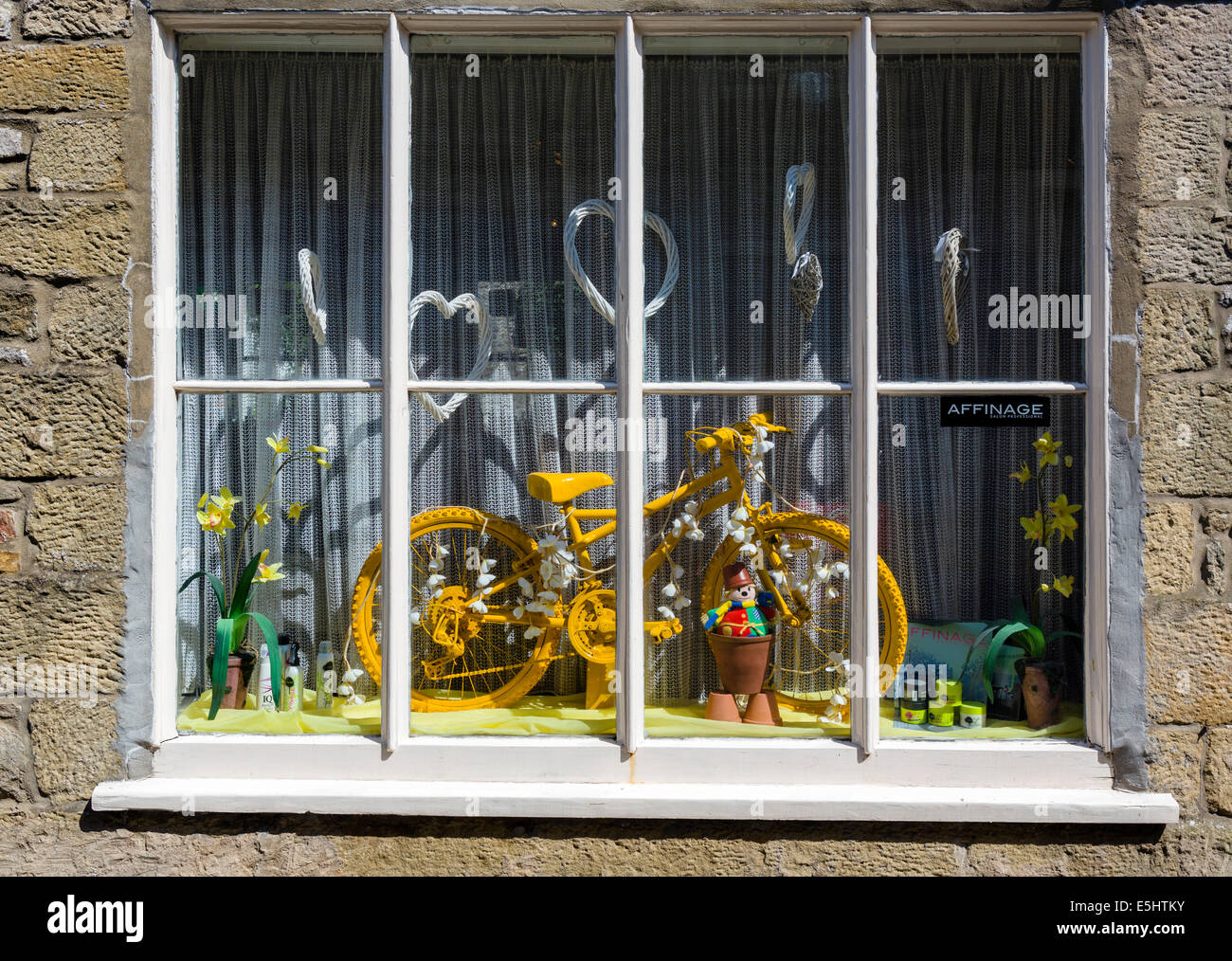 Yellow bicycle in a shop window, celebration the 2014 Tour de France Grand Depart in Yorkshire, Settle, North Yorkshire, UK Stock Photo