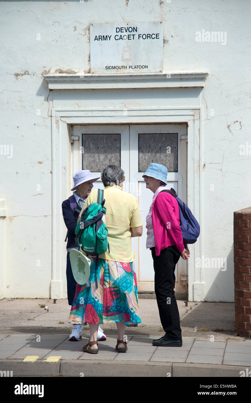 3 elderly ladies stop for a chat outside the Army Cadet Force HQ in Sidmouth Devon UK Stock Photo