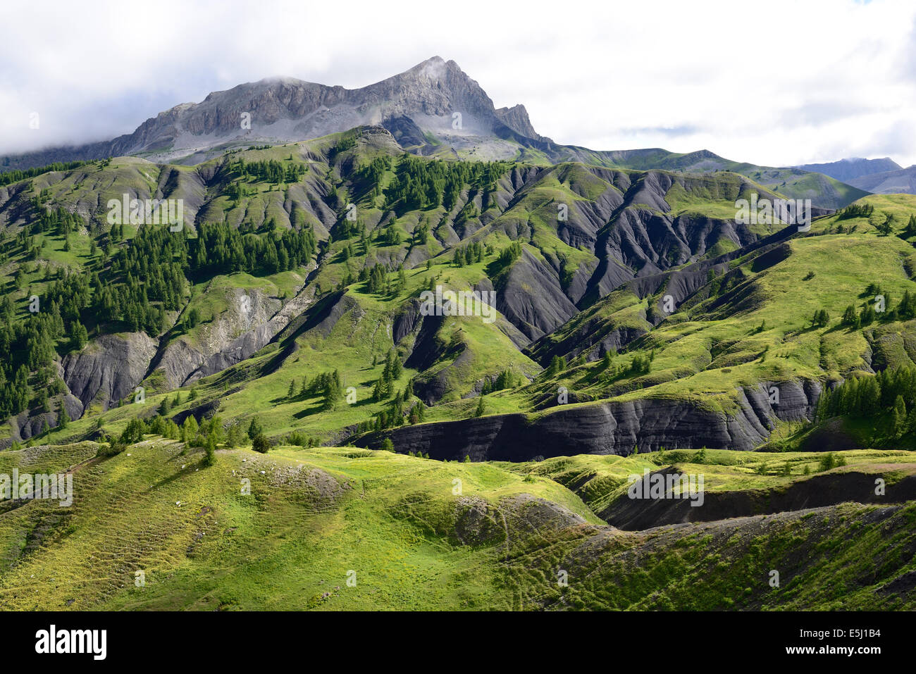 Landscape of a grassy hillside with dark ravines in the Mercantour National Park. Col des Champs, Alpes-de-Haute-Provence and Alpes-Maritimes, France. Stock Photo