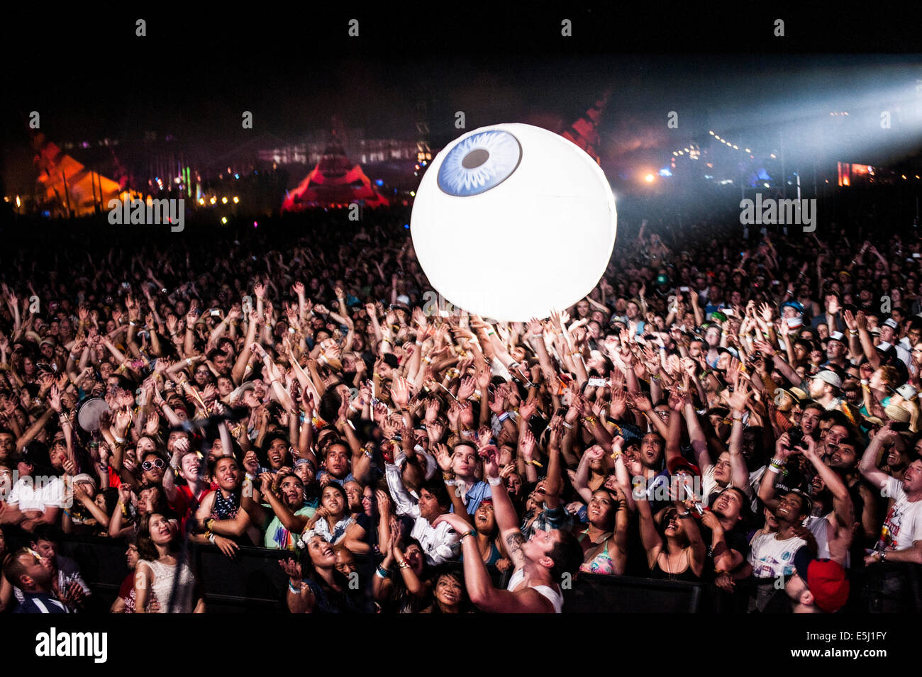 Music fans bouncing a beach ball type of blow up eyeball ball through a massive crowd at the Coachella Music Festival Stock Photo