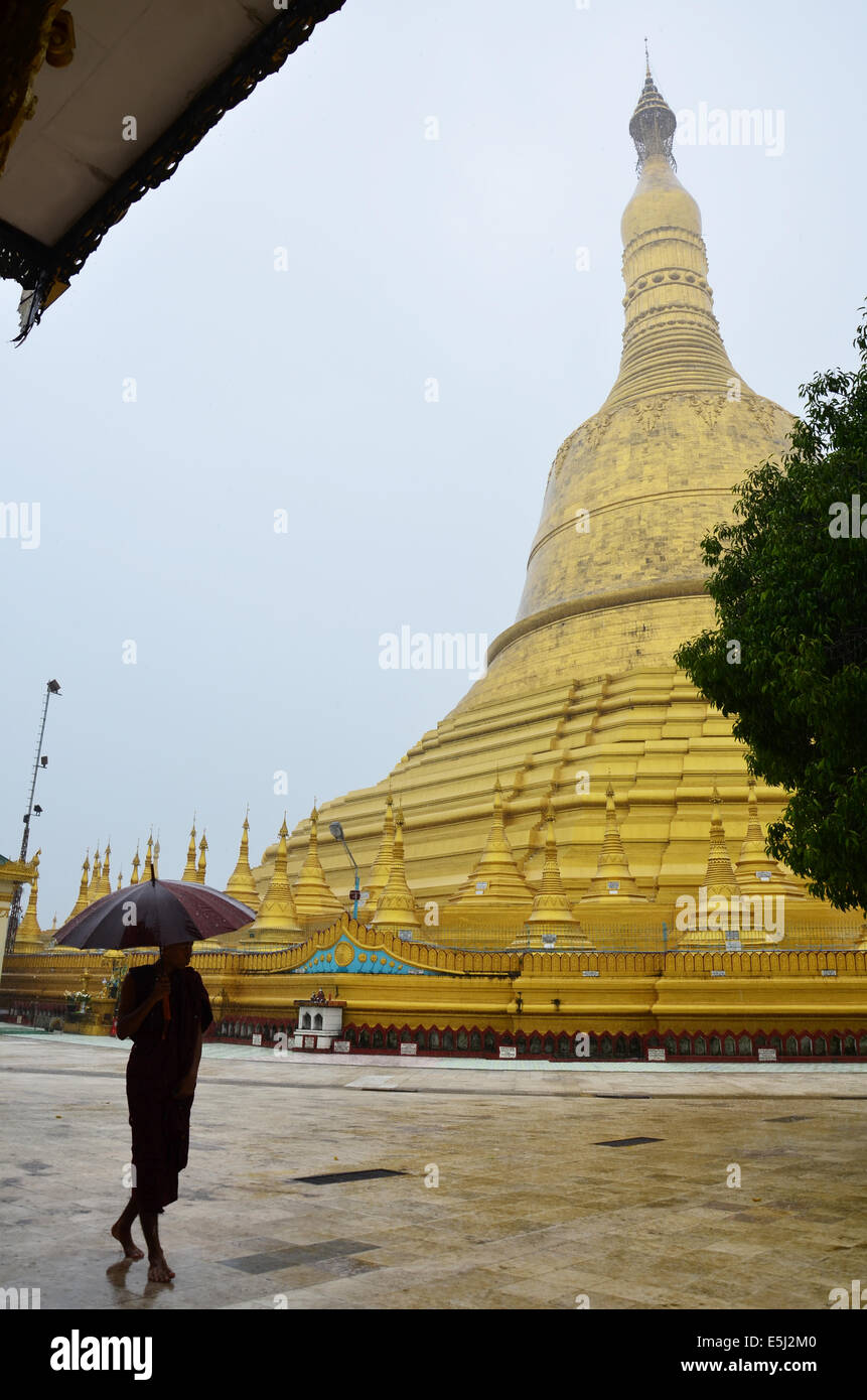 Buddhist or monk walking at Shwemawdaw Paya Pagoda is a stupa located in Bago, Myanmar in raining time Stock Photo
