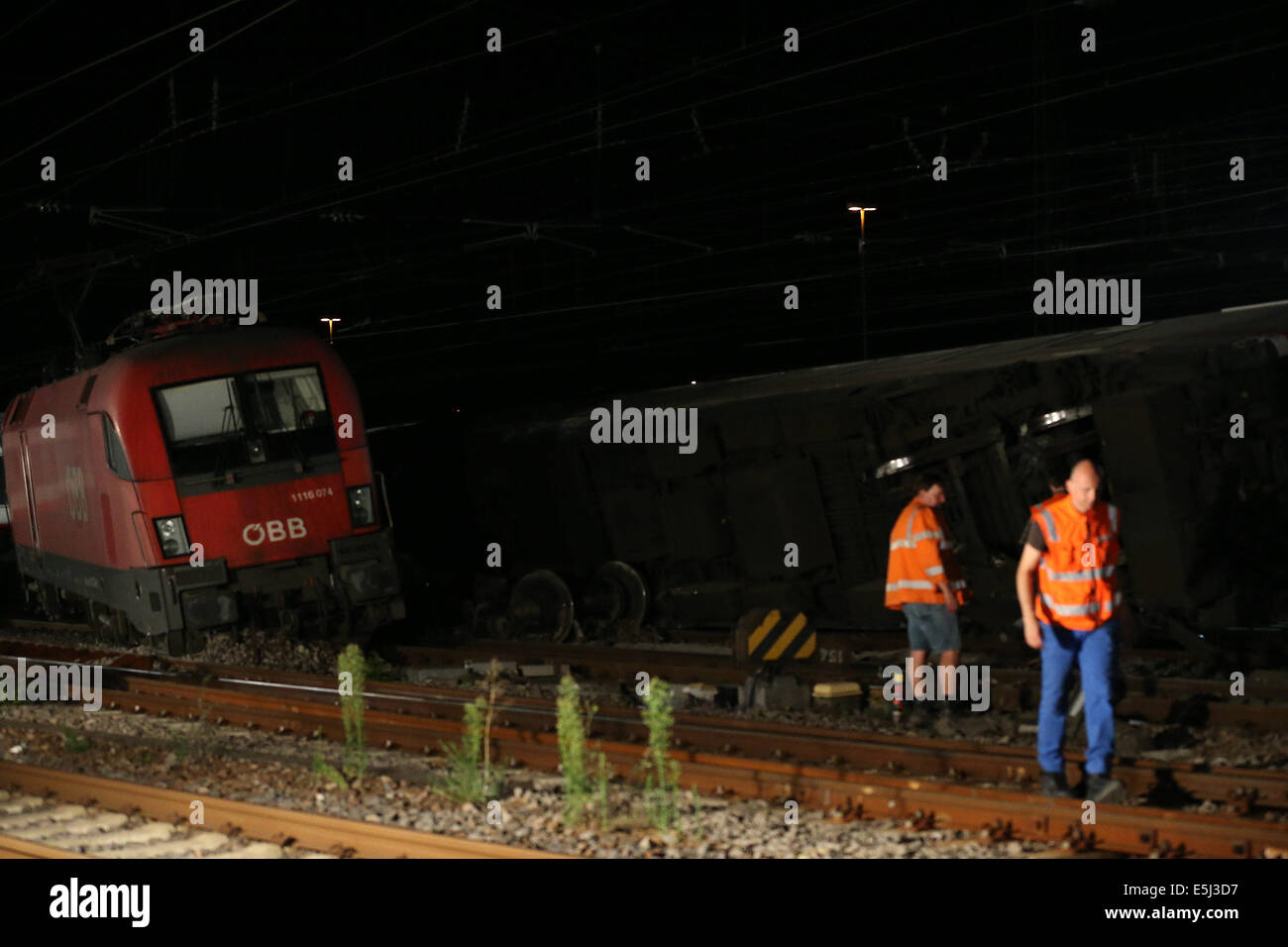 Mannheim, Germany. 1st Aug, 2014. Rescuers gather at the accident scene where a passenger train collided with a freight train, in the southern German city of Mannheim, Aug. 1, 2014. According to local police, the accident happened at around 9:00 p.m. local time (1900 GMT) on Friday. A freight train ran into a passenger train at the central railway station in Mannheim and brought the latter to derailment. More than 20 people were injured in the accident. (Xinhua/Luo Huanhuan) (lyi) Stock Photo