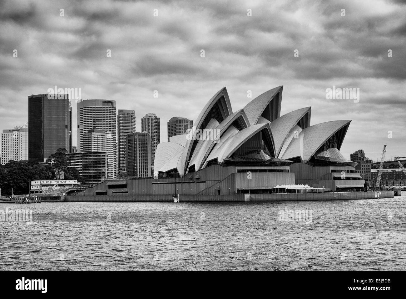 Sydney Opera House on Bennelong Point, taken from onboard the Manly Ferry on Sydney Harbour, Australia. Black and white photograph. July 2014 Stock Photo