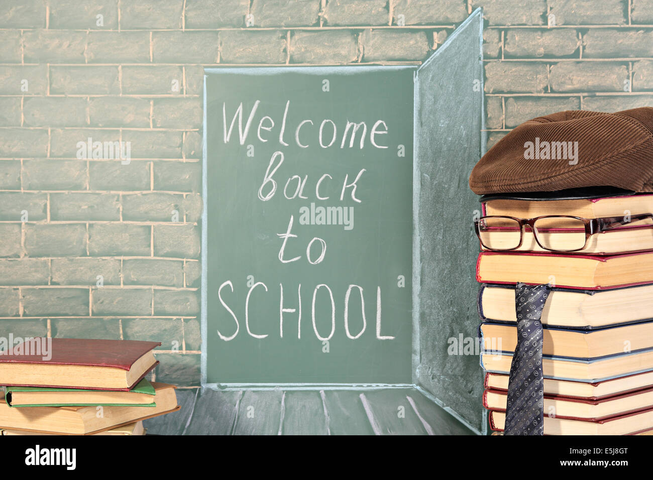 Back to school idea with text on chalkboard and teacher from books Stock Photo