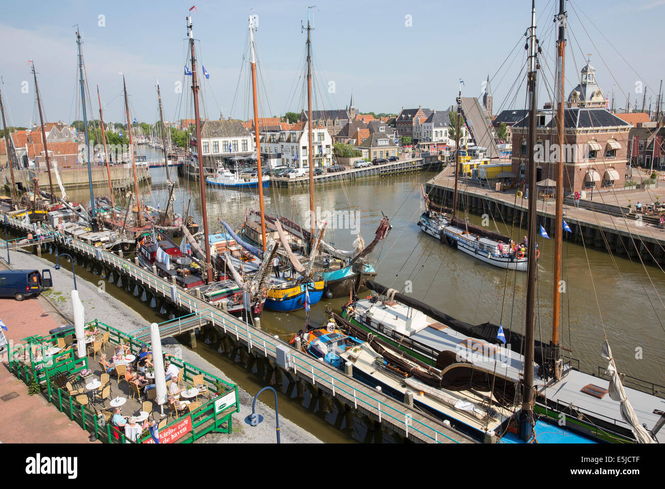 Netherlands, Harlingen, Harbor. Traditional sailing boats and outdoor terrace Stock Photo