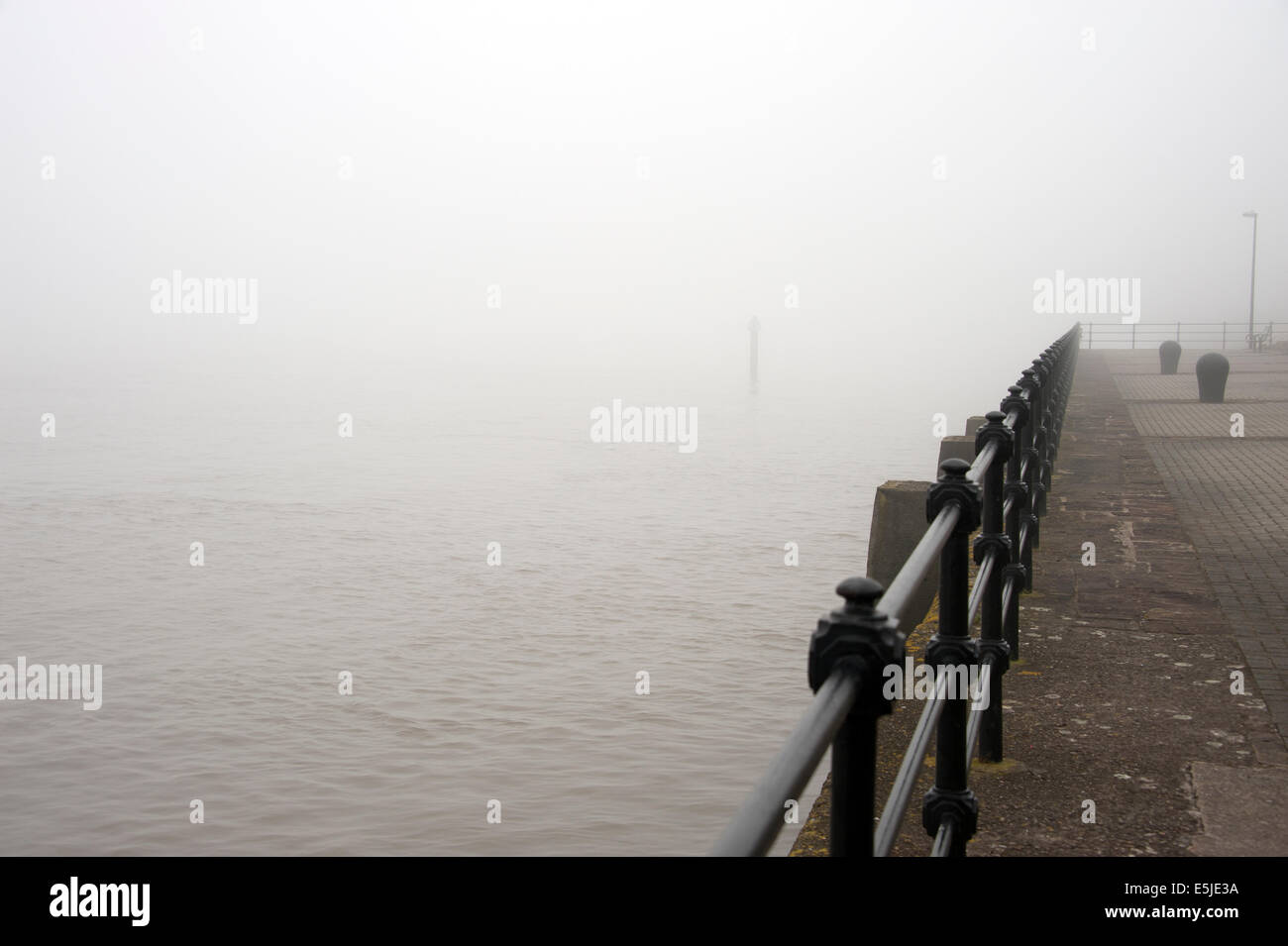 sea mist fog thick railings disappear in to Stock Photo