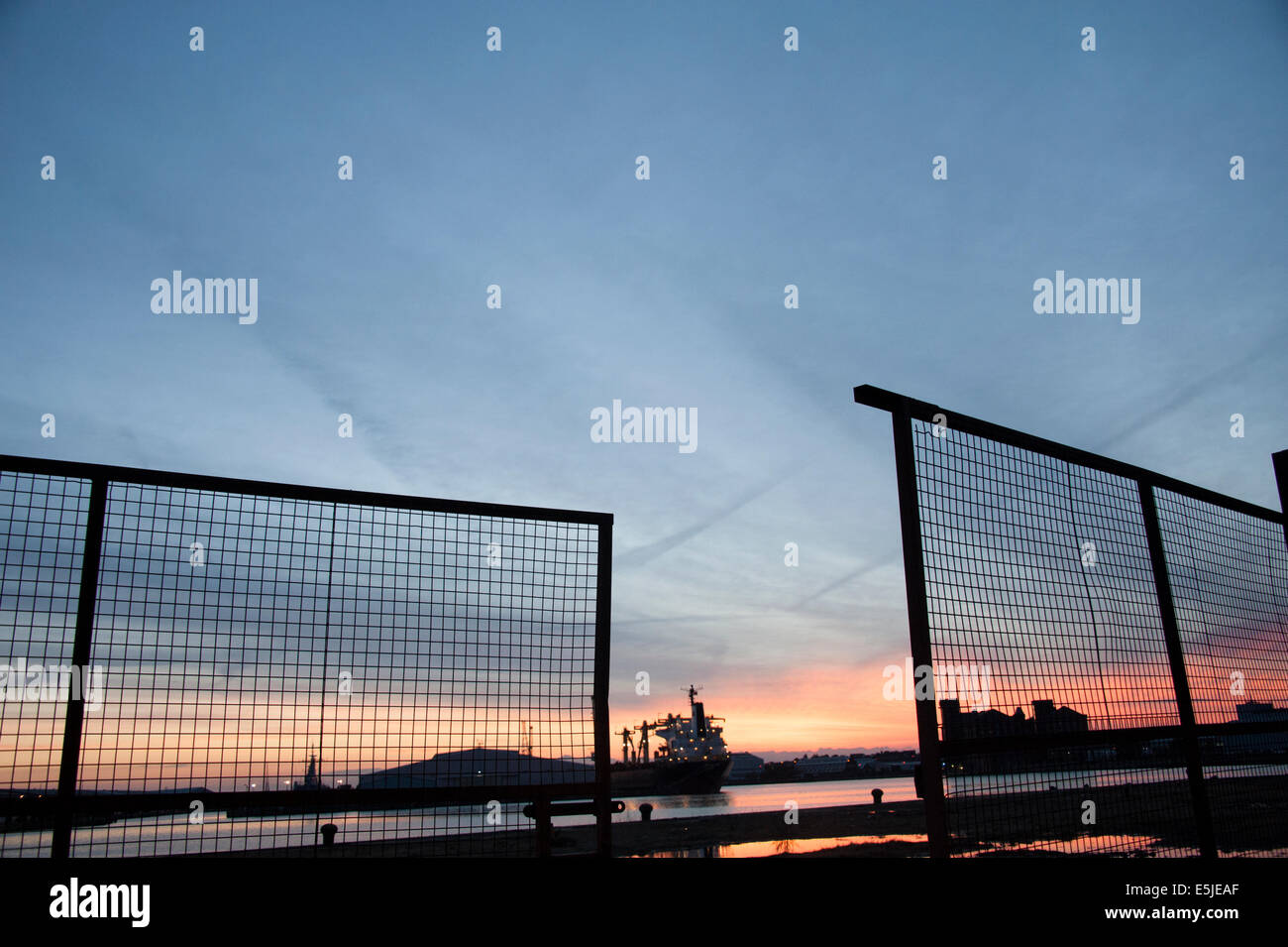 Ship in dock at sunset silhouette red orange sky Stock Photo - Alamy