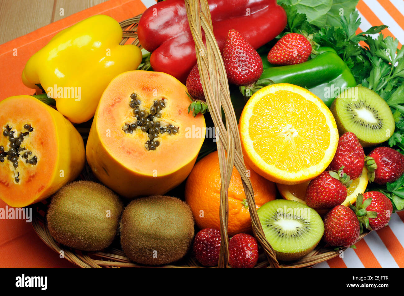 Healthy diet - sources of Vitamin C - oranges, strawberry, bell pepper capsicum, kiwi fruit, paw paw, spinach dark leafy greens Stock Photo