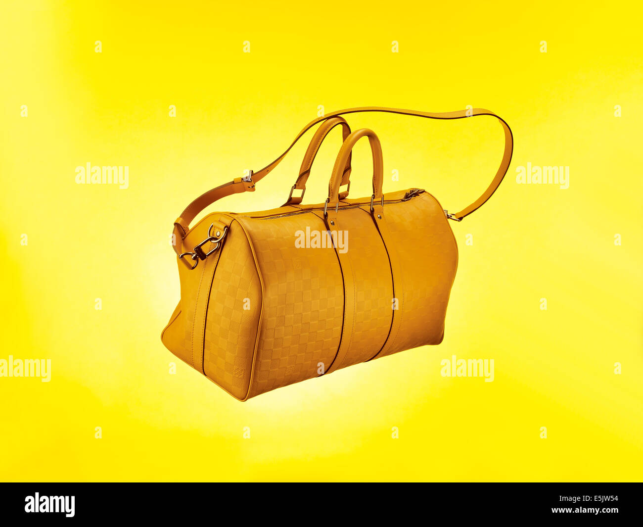Bag flying with straps against a yellow background Stock Photo