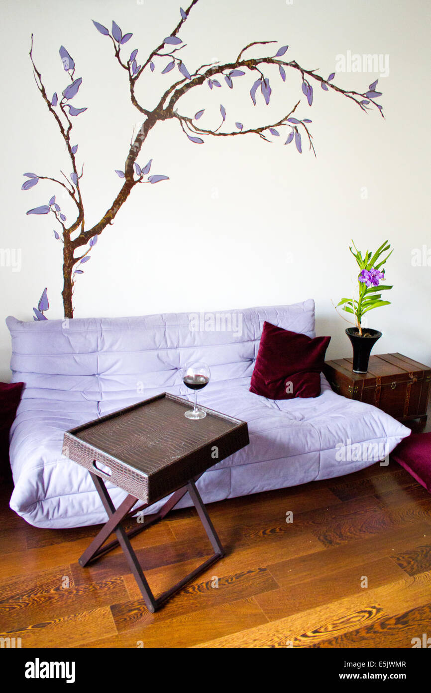 Minimalist living design with purple sofa, wooden box and elegant decorations Stock Photo