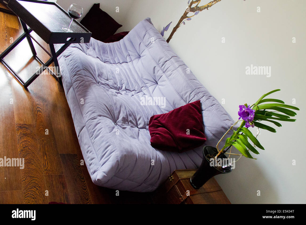 Minimalist living design with purple sofa, wooden box and elegant decorations Stock Photo