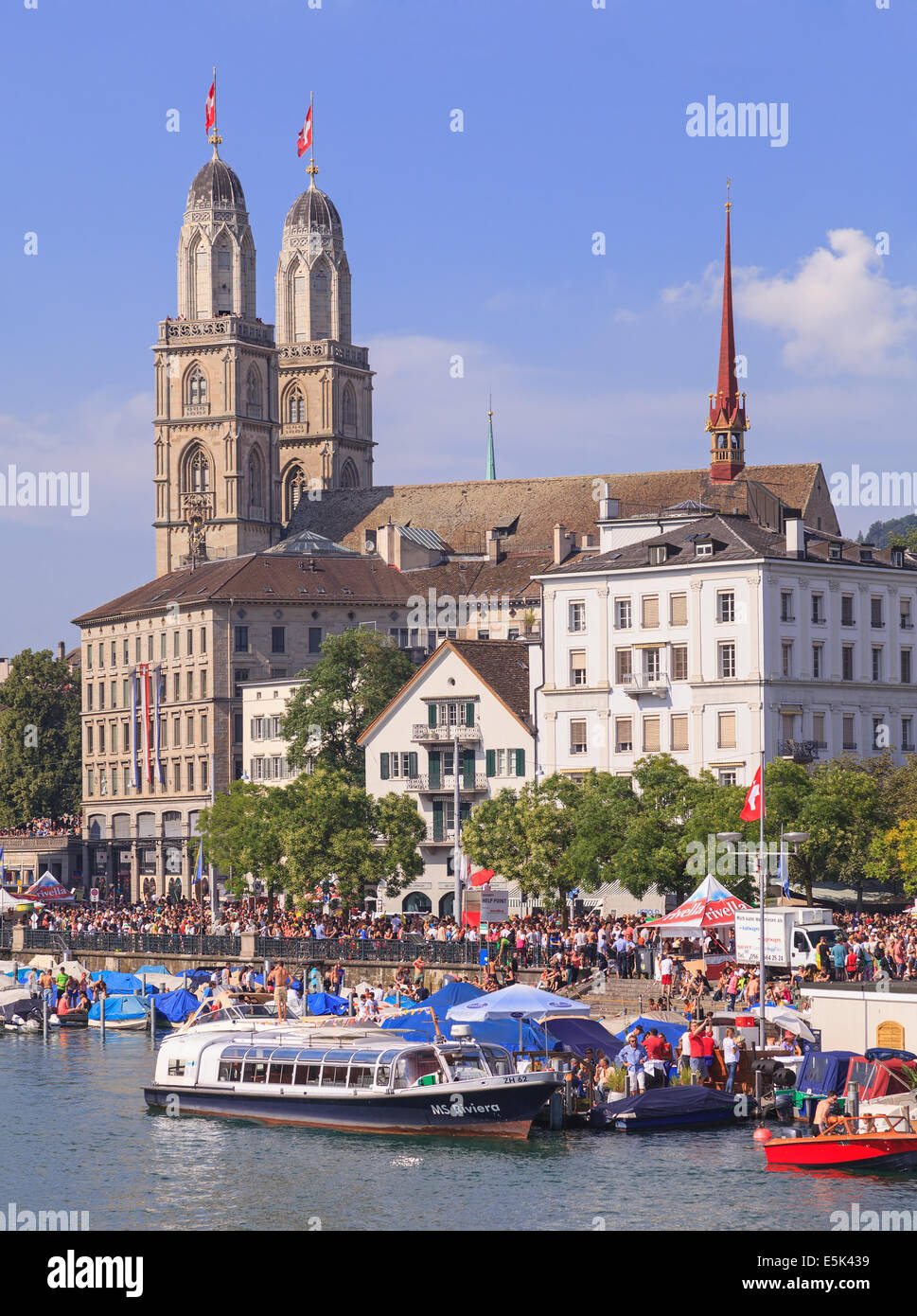 Zurich, Switzerland - 2 August, 2014: the Great Minster Cathedral (German: Grossmunster) and the Limmatquai quay during the Stre Stock Photo