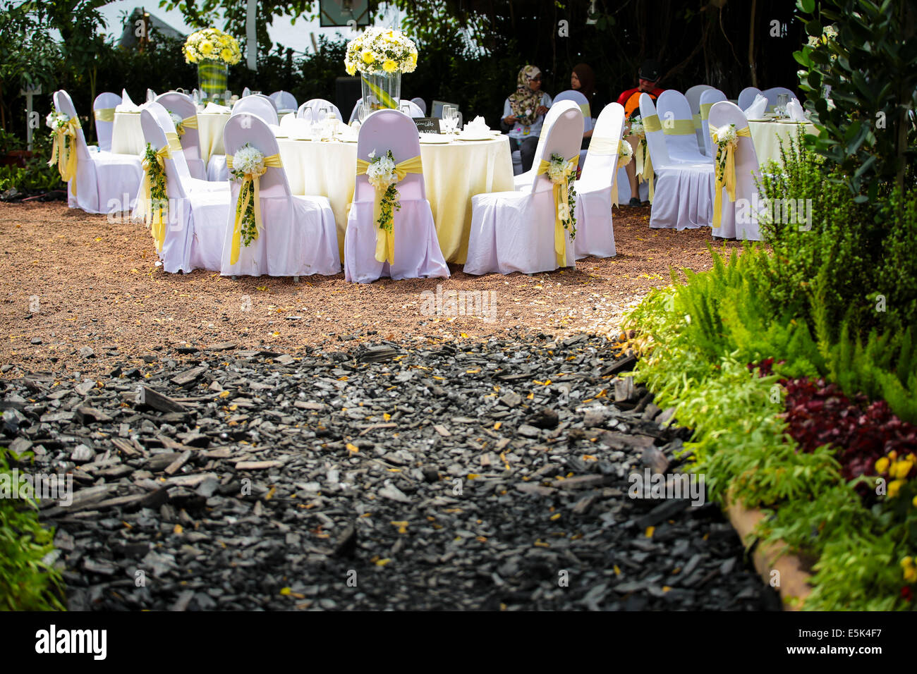 Wedding table setting at an outdoor garden with charcoal filled track. Stock Photo