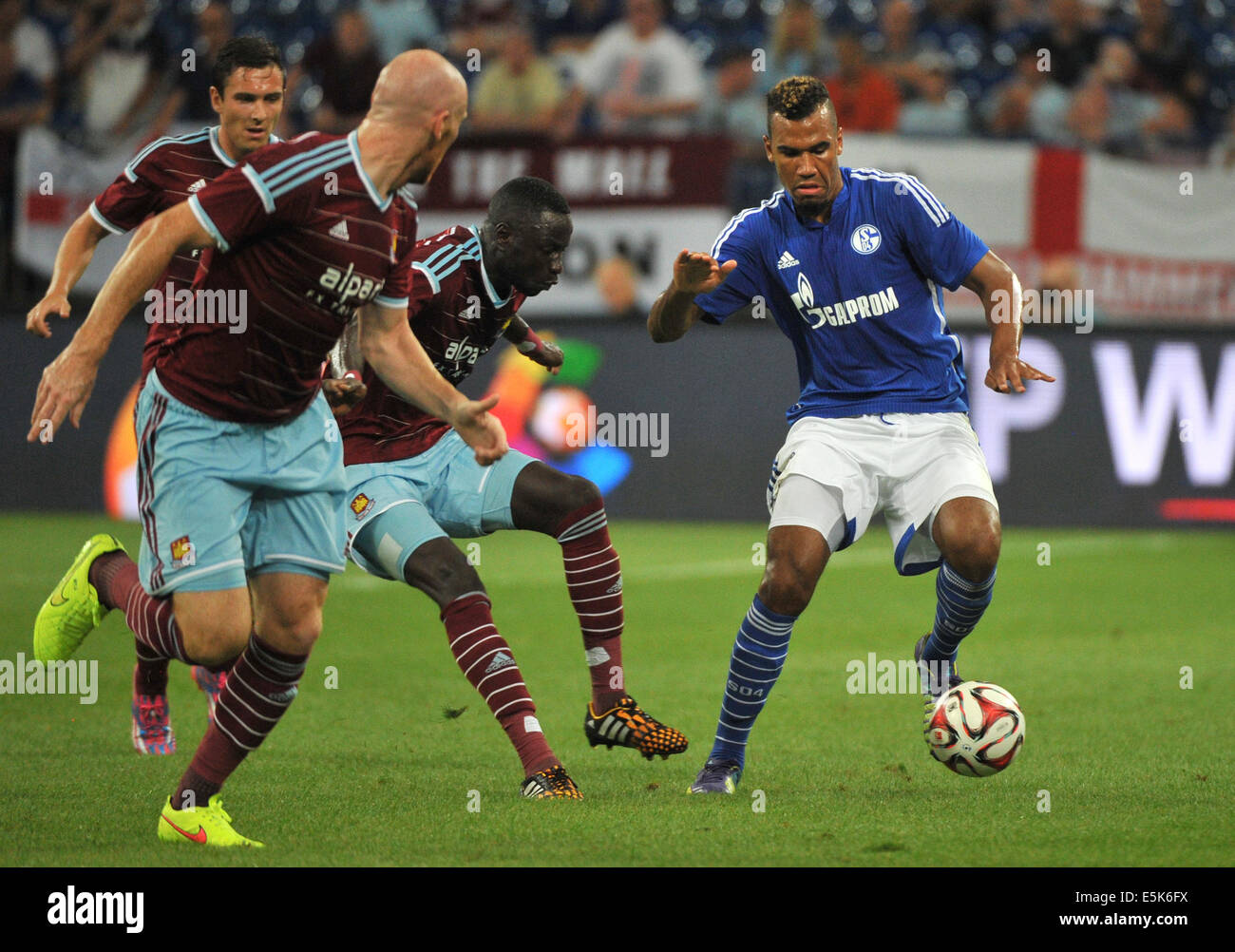 Gelsenkirchen, Germany. 02nd Aug, 2014. Schalke's Eric Maxim Choupo-Moting (R) against West Ham's Cheikhou Kouyate (2-R) during the soccer test match Schalke Cup between FC Schalke 04 and West Ham United at Veltins-Arena in Gelsenkirchen, Germany, 02 August 2014. Photo: Matthias Balk/dpa/Alamy Live News Stock Photo