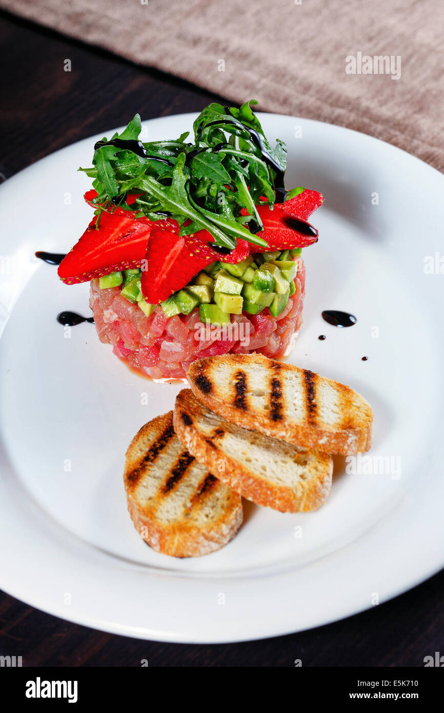 Tuna tartare with fruit strawberries and toasted toast shot closeup in