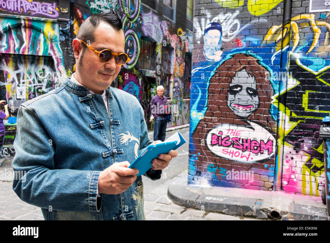 Melbourne Australia,Hosier Lane,urban street art,graffiti,murals,Asian man men male,tablet,iPad,AU140322067 Stock Photo