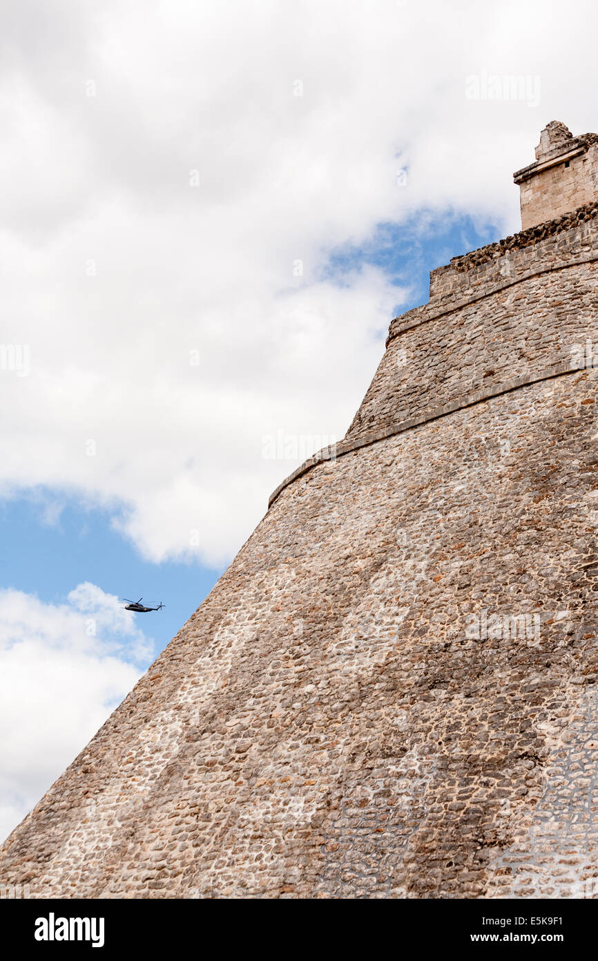 Military site seeing at Uxmal. A military helicopter circles the iconic pyramid at Uxmal. Stock Photo
