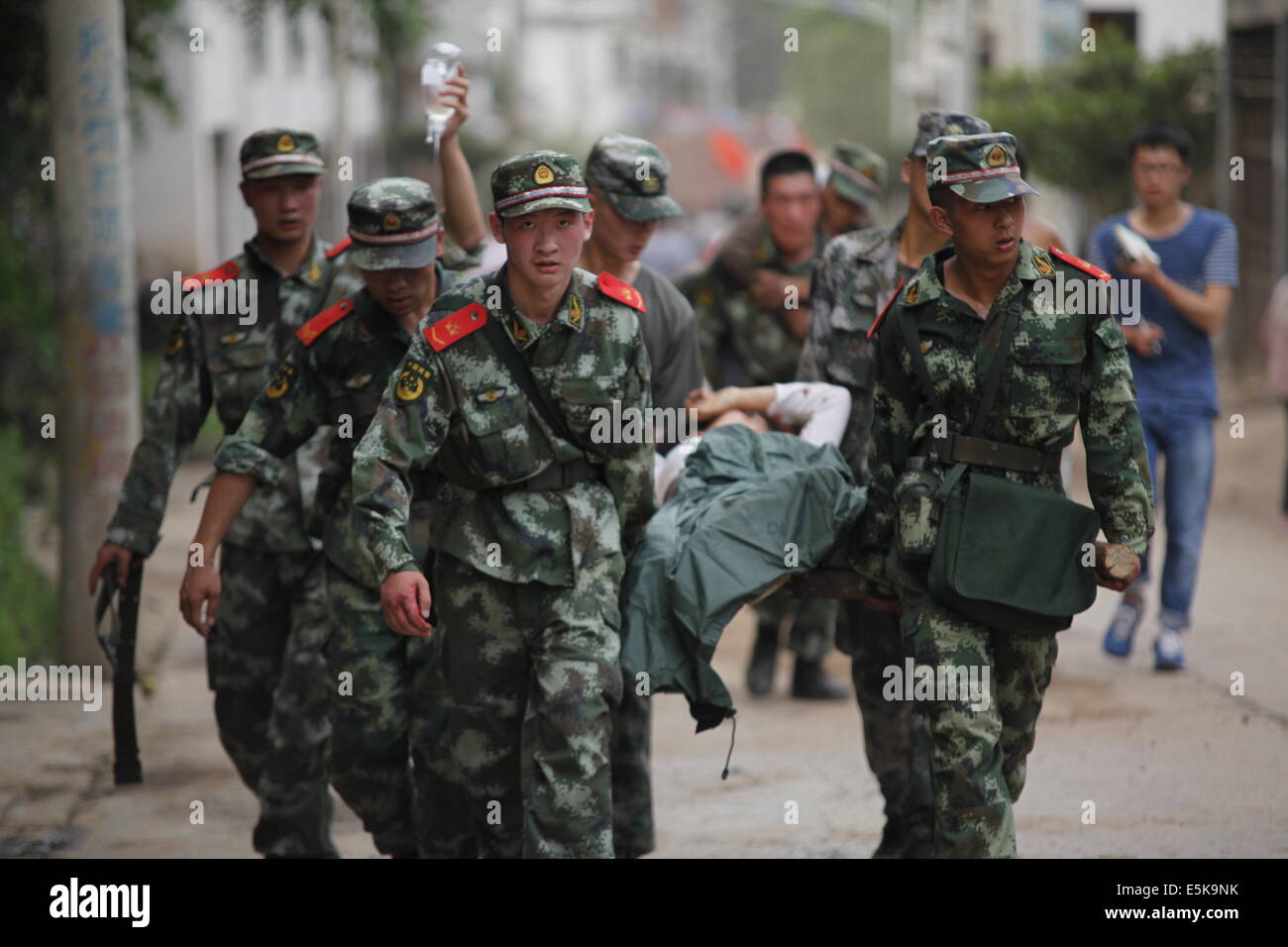 Zhaotong. 3rd Aug, 2014. Rescuers transport injured people after an earthquake in Ludian County of Zhaotong City in southwest China's Yunnan Province, Aug. 3, 2014. A 6.5-magnitude earthquake jolted Ludian County at 4:30 p.m. Sunday (Beijing Time), said the China Earthquake Networks Center (CENC). The Ministry of Civil Affairs has reported that the updated number of casualty is 175 dead and 181 missing. Credit:  Zhang Guangyu/Xinhua/Alamy Live News Stock Photo