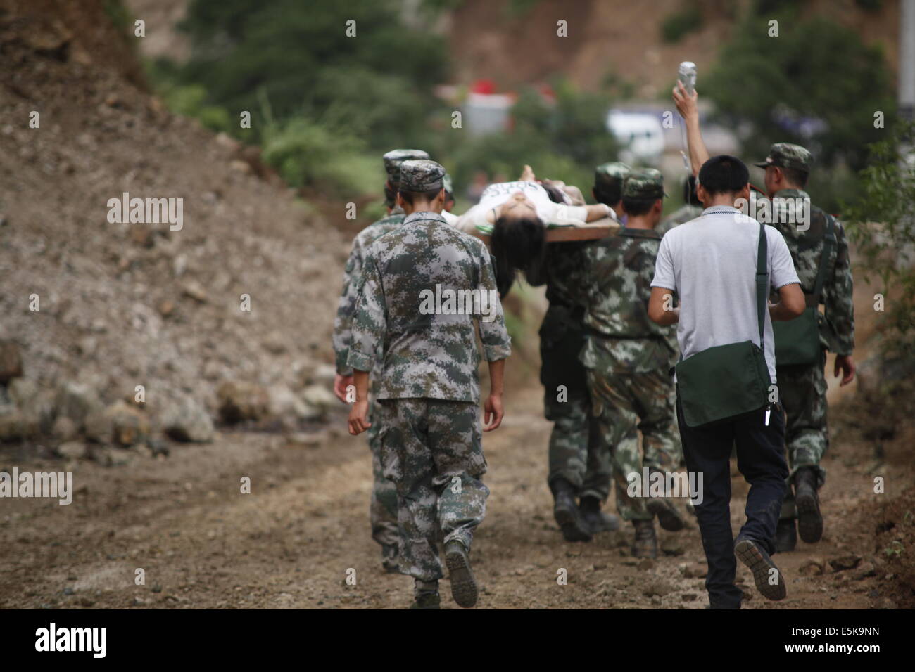 Zhaotong. 3rd Aug, 2014. Rescuers transport an injured woman after an earthquake in Ludian County of Zhaotong City in southwest China's Yunnan Province, Aug. 3, 2014. A 6.5-magnitude earthquake jolted Ludian County at 4:30 p.m. Sunday (Beijing Time), said the China Earthquake Networks Center (CENC). The Ministry of Civil Affairs has reported that the updated number of casualty is 175 dead and 181 missing. Credit:  Zhang Guangyu/Xinhua/Alamy Live News Stock Photo