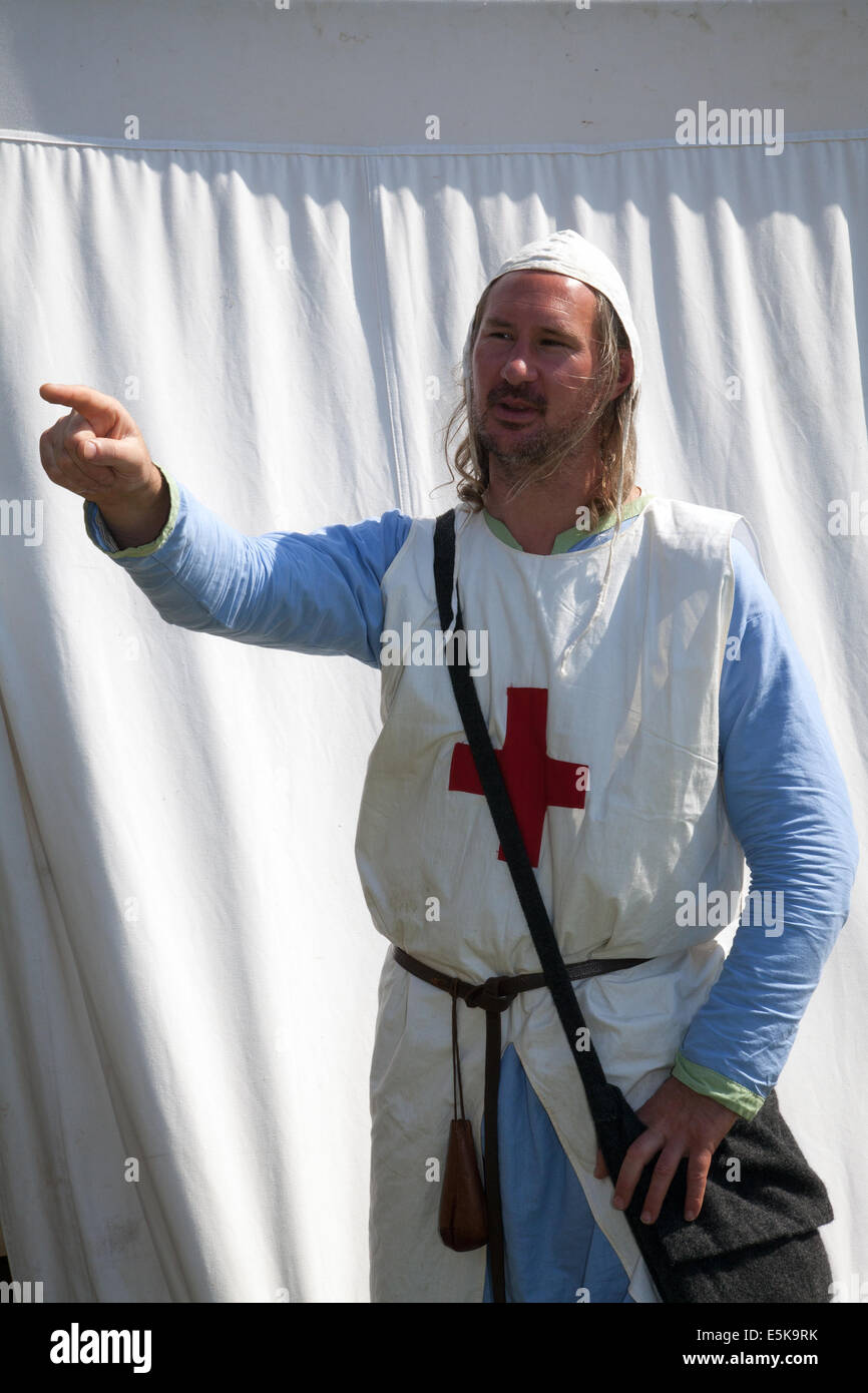 Beeston, Cheshire, UK 3rd August, 2014.  William Freeman from Bolsover, a Medieval Templer Knight at the Tournament held at Beeston Castle, wearing a male nurse uniform Medieval medic special costume nurse. Historia Normannis a 12th century early medieval physician at the reenactment group event. Stock Photo