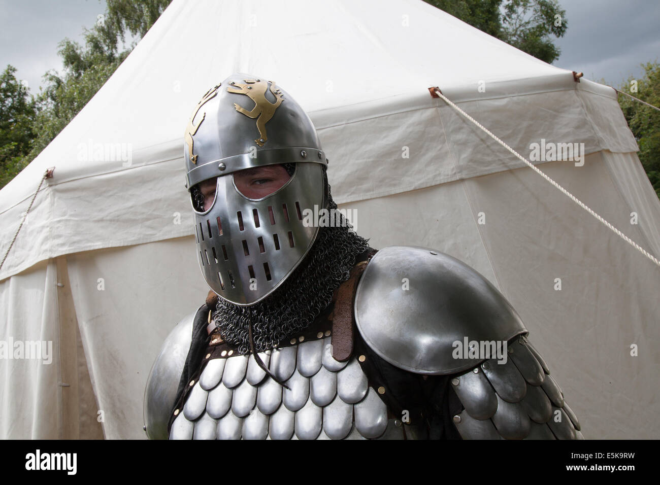 Armed swordsman in full military armour with chain mail, sword, and helmet, swordsman, sword fight, warrior, man, weapon, medieval, traditional knight, protective clothing, martial, male at Beeston Castle in Cheshire, England.  Historia Normannis is a 12th century early armoured medieval reenactment group at English Heritage site. Stock Photo