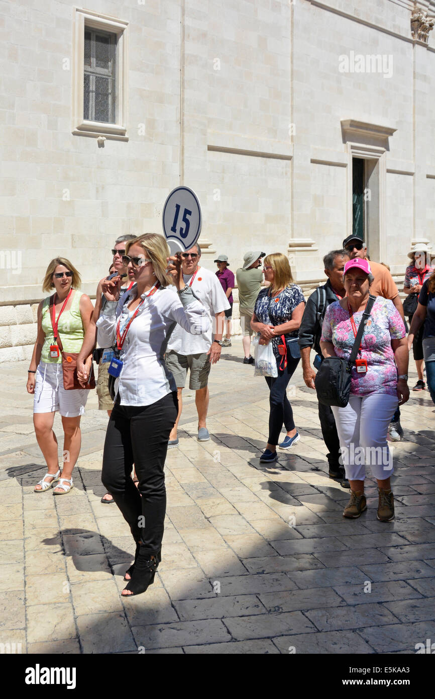 Tour guide holding cruise ship tour number flag board & talking real time into mike linking audio to her group Dubrovnik Croatia Dalmatia Adriatic Stock Photo