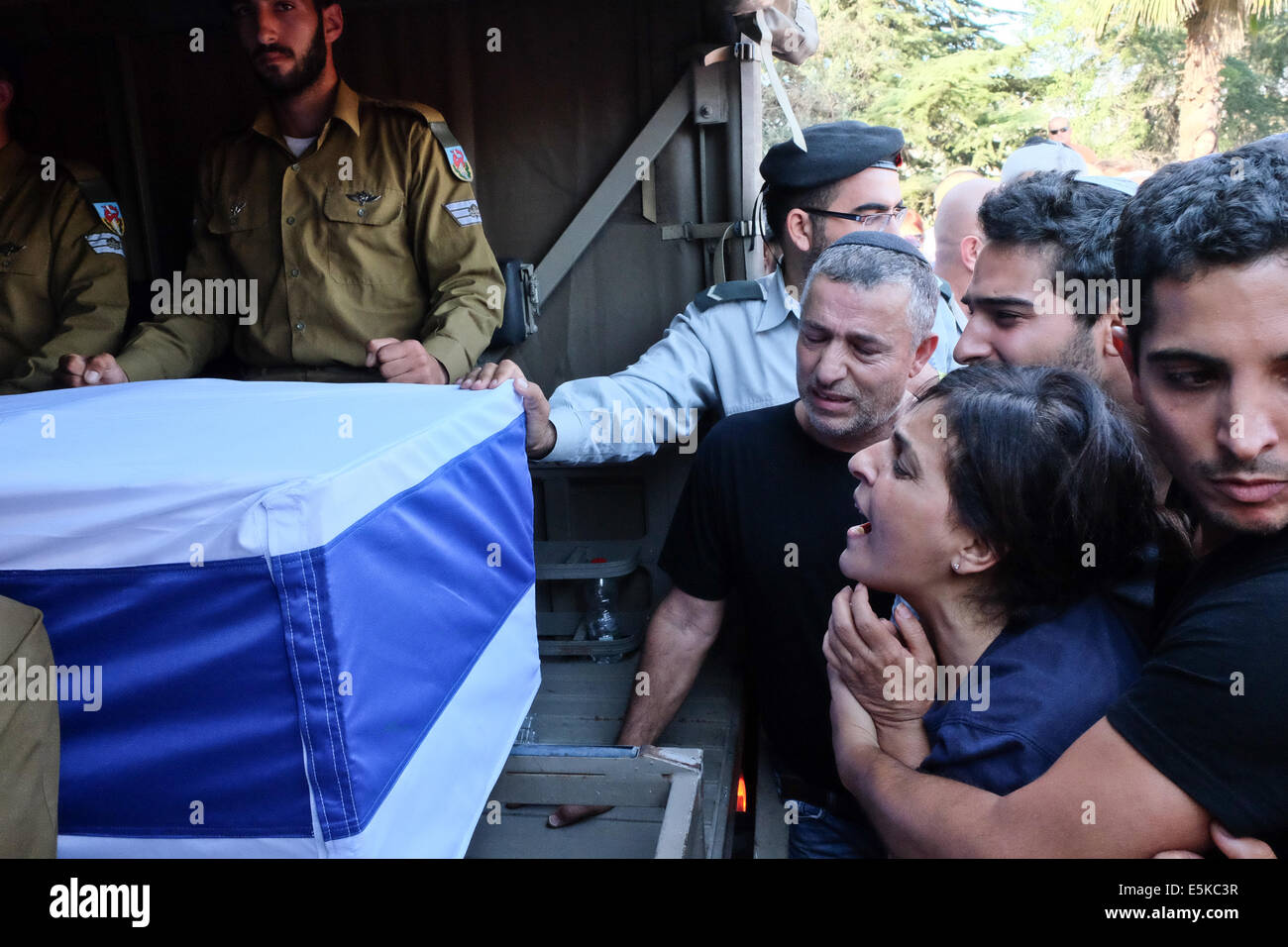 Mount Herzl, Jerusalem, Israel. 3rd Aug, 2014. Mother, MAZAL GIDONI, cries out as her son's coffin arrives in a military vehicle for burial. IDF St.-Sgt. Liel Gidoni, 20, was brought to rest at the Mount Herzl Military Cemetery. Gidoni, a soldier in the Givati Brigade, 'the purple brigade', was killed in Rafah in the Gaza Strip in the ongoing Israeli military offensive, Operation Protective Edge, during a ceasefire broken by Hamas. Credit:  Nir Alon/Alamy Live News Stock Photo