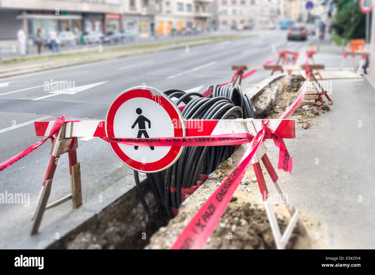 Road excavation at a construction site at conduits for the laying of fibre optic and electric cable Stock Photo