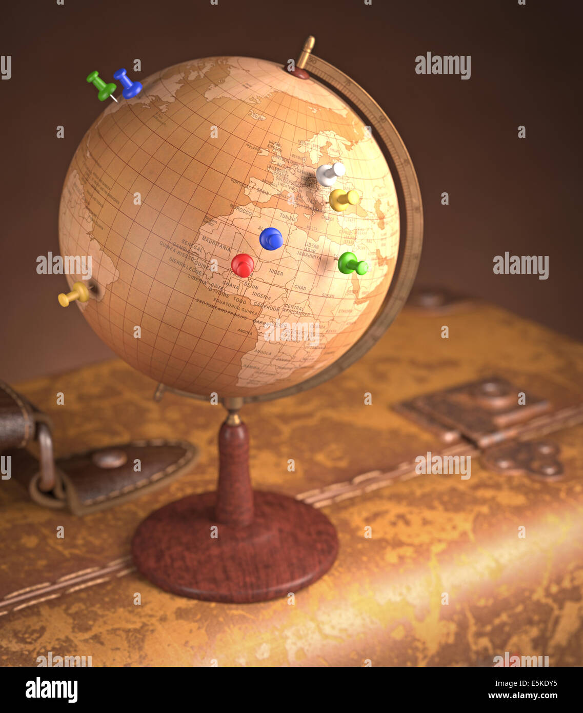 Old globe with pins marking the route of the trip on top a vintage suitcase. Stock Photo