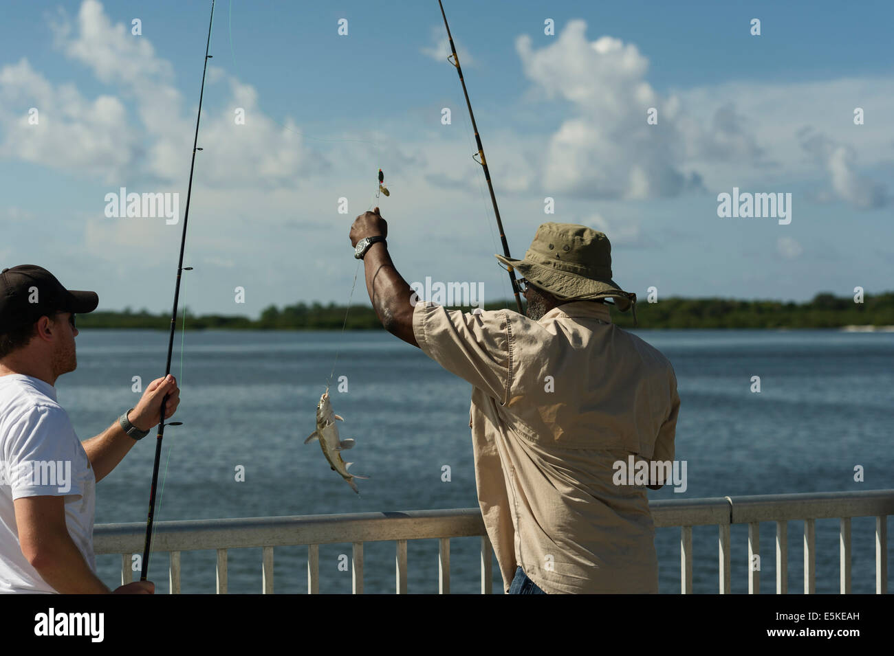 Two men fishing on a public pier in Cedar Key, Florida USA Stock Photo