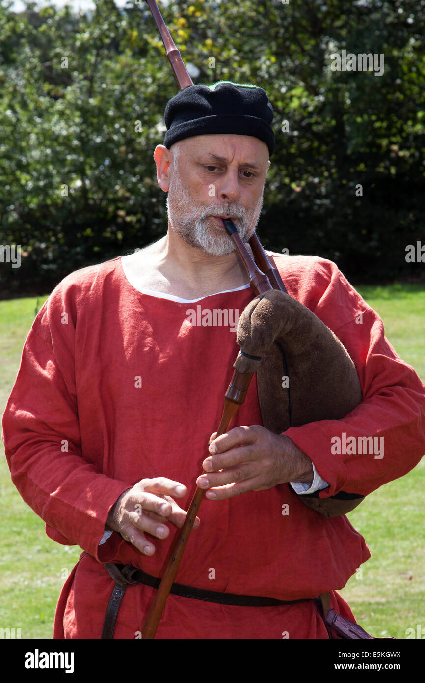Beeston, Cheshire, UK 3rd August, 2014.  A Musician piper at the Medieval Knights Tournament held at Beeston Castle in Cheshire, England.  Historia Normannis a 12th century early medieval reenactment group provided an event at the English Heritage site. Stock Photo