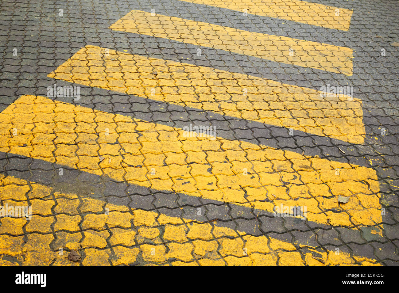 Pedestrian crossing, yellow marking on cobblestone road pavement Stock Photo