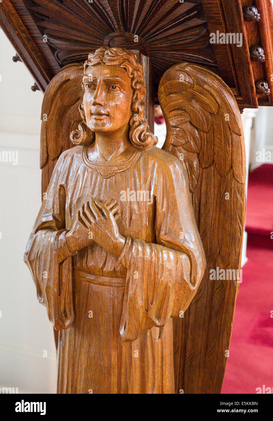 Angel Carved from a single Piece of Oak Wood. A carved winged man decorates the lectern at St Paul Lutheran Church. Stock Photo