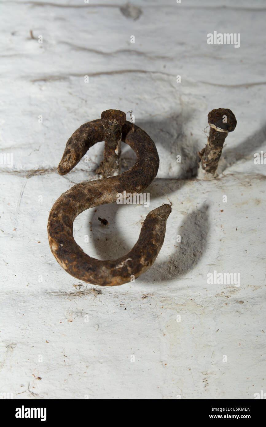 Close-up of a rusty 'S' shaped metal hook and screws.  Dogdyke Steam Pumping Station. Tattershall, Lincolnshire Stock Photo